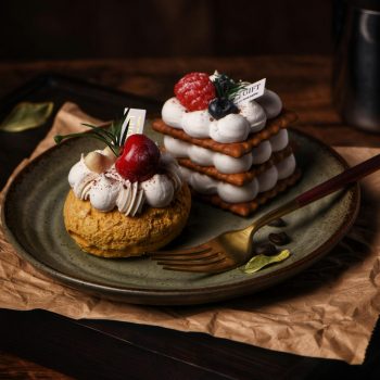Delicious puff pastries topped with berries served on a rustic plate.