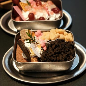 Close-up of a dessert with toppings in a metal tray, ideal for food enthusiasts.